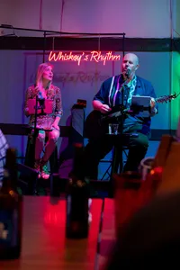 Two people singing together on a small stage