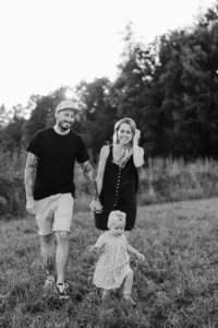 Familie spaziert Hand in Hand durchs Feld – authentische Familienfotografie Schweiz