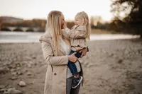Familienshooting am Wasser im Aargau – liebevoller Moment zwischen Mutter und Tochter im Abendlicht