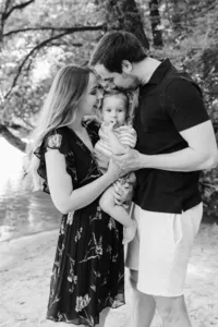 Familie mit Kleinkind am Flussufer – natürliche Familienfotografie in Schwarz-Weiss