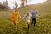 Natürliches Familienshooting im Aargau – Familie läuft lachend über eine Blumenwiese