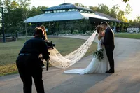 A newlywed couple being recorded by a videographer