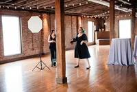 Mahlia and assistant standing inside Cannery wedding venue as she directs the bride