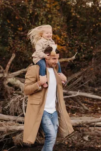 Lebendige Familienfotos im Aargau – Vater trägt Tochter beim Outdoorshooting