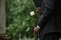 black-man-holding-white-rose-before-placing-flower-2025-03-10-07-49-14-utc