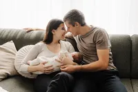 Eltern mit Neugeborenem auf dem Sofa – natürliche Newbornfotografie Schweiz