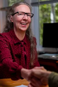 A person sitting at a desk smiling