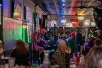 A small bar with two people playing music