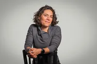 A person sitting backwards in a chair smiling