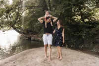 Familie spaziert barfuss am Flussufer – natürliche Familienfotografie Schweiz