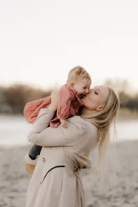 Natürliche Familienfotografie im Aargau – Mutter küsst ihr Baby beim Outdoorshooting