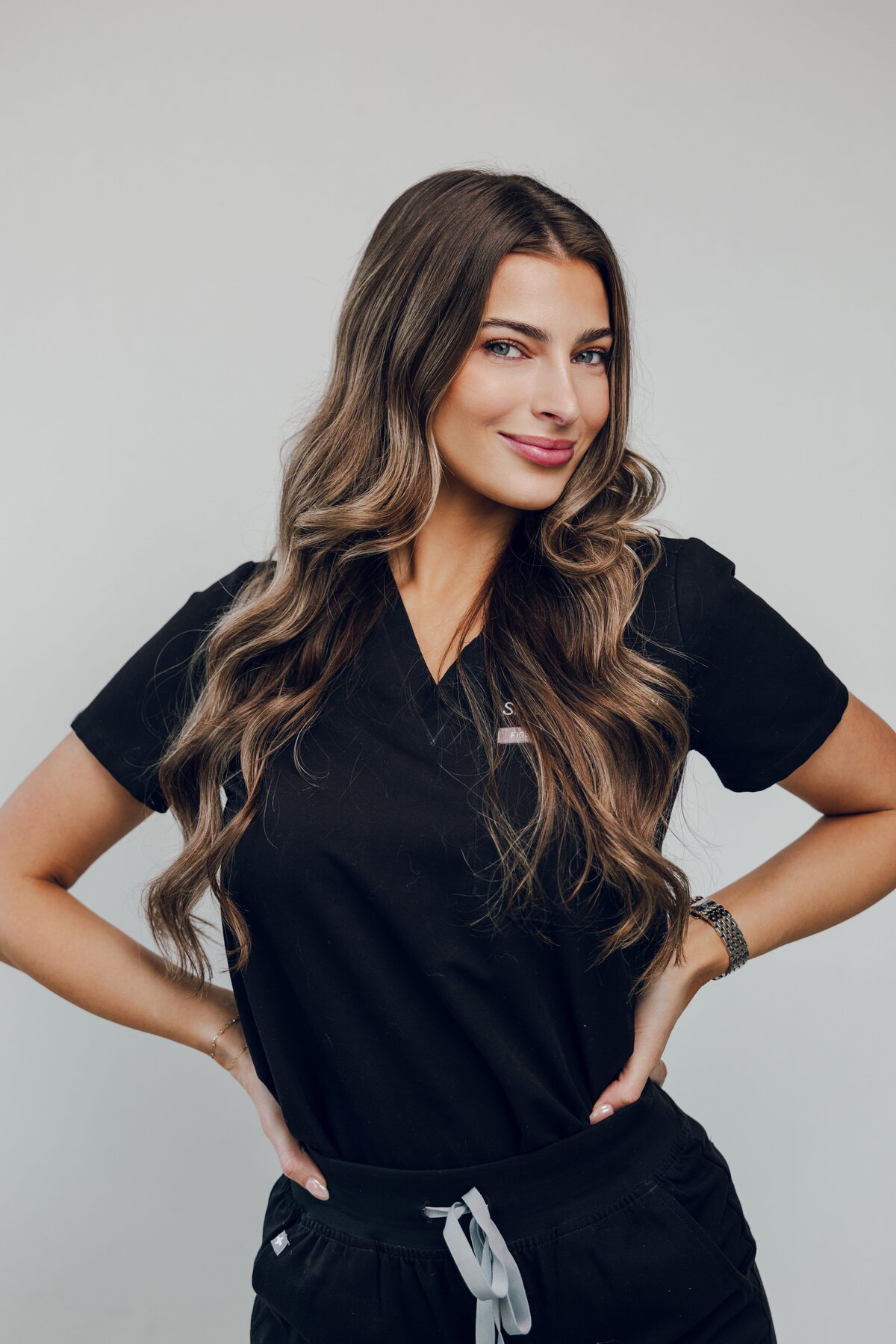 Team member in black scrubs with hands on hips
