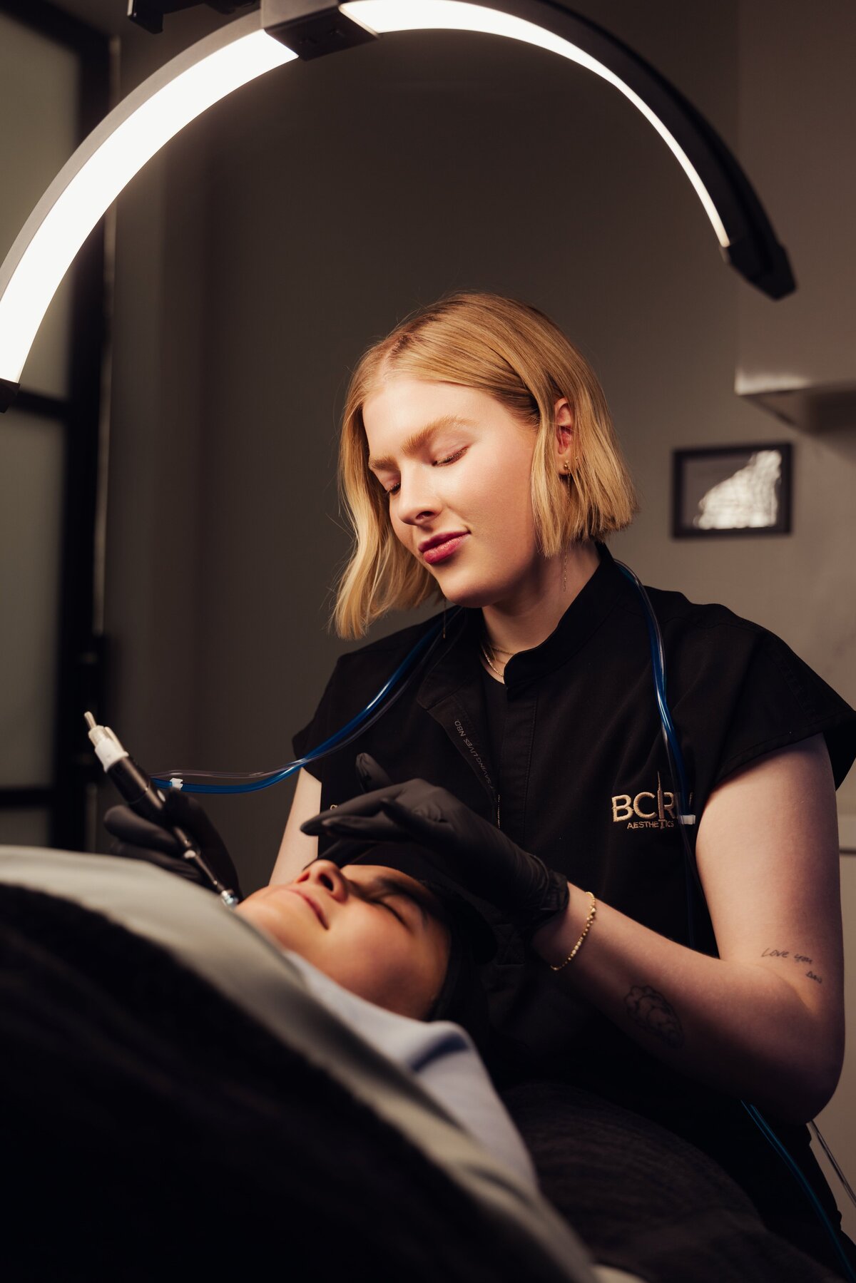 Provider giving a facial treatment under a ring light at BCRN Aesthetics