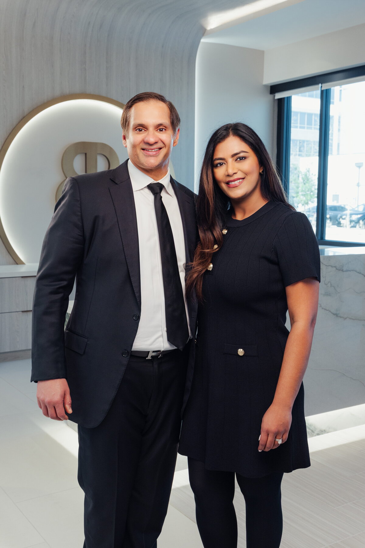 Surgeon in a suit and a team member standing together in the lobby