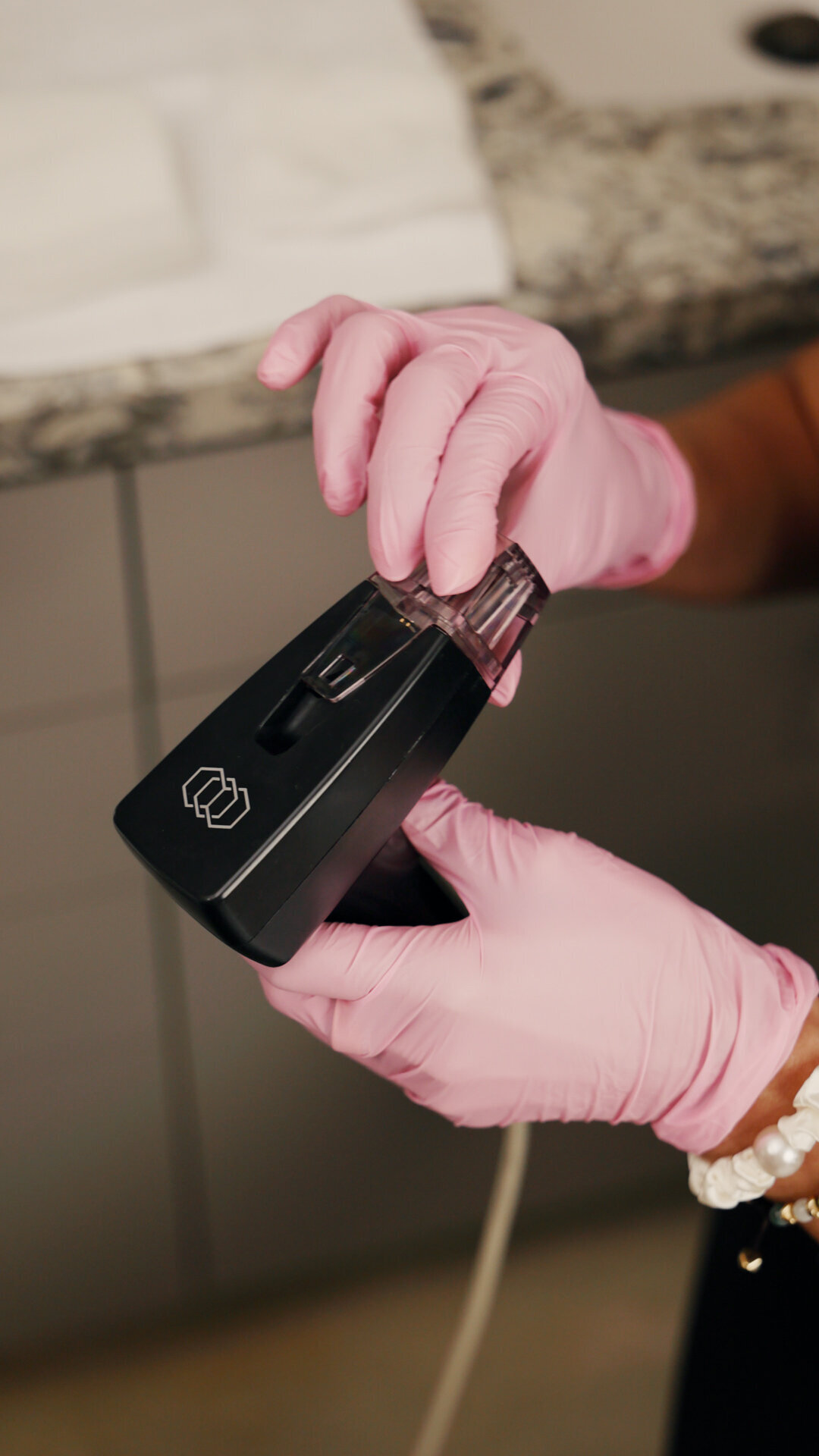 Gloved hands holding a treatment device