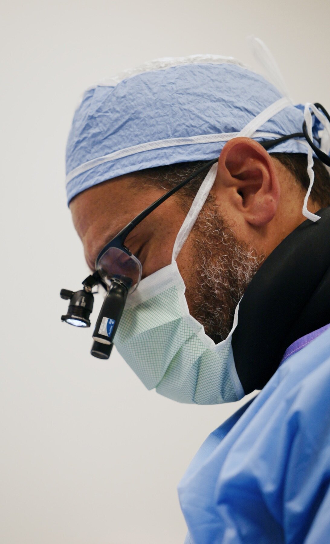 Surgeon wearing loupes and a mask during a procedure