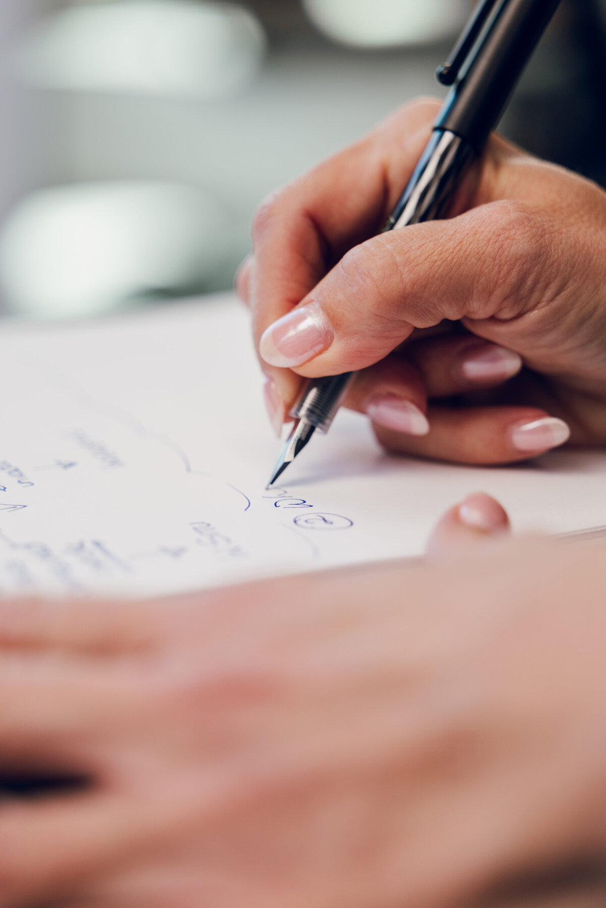 Close-up of a hand sketching on paper during a consultation