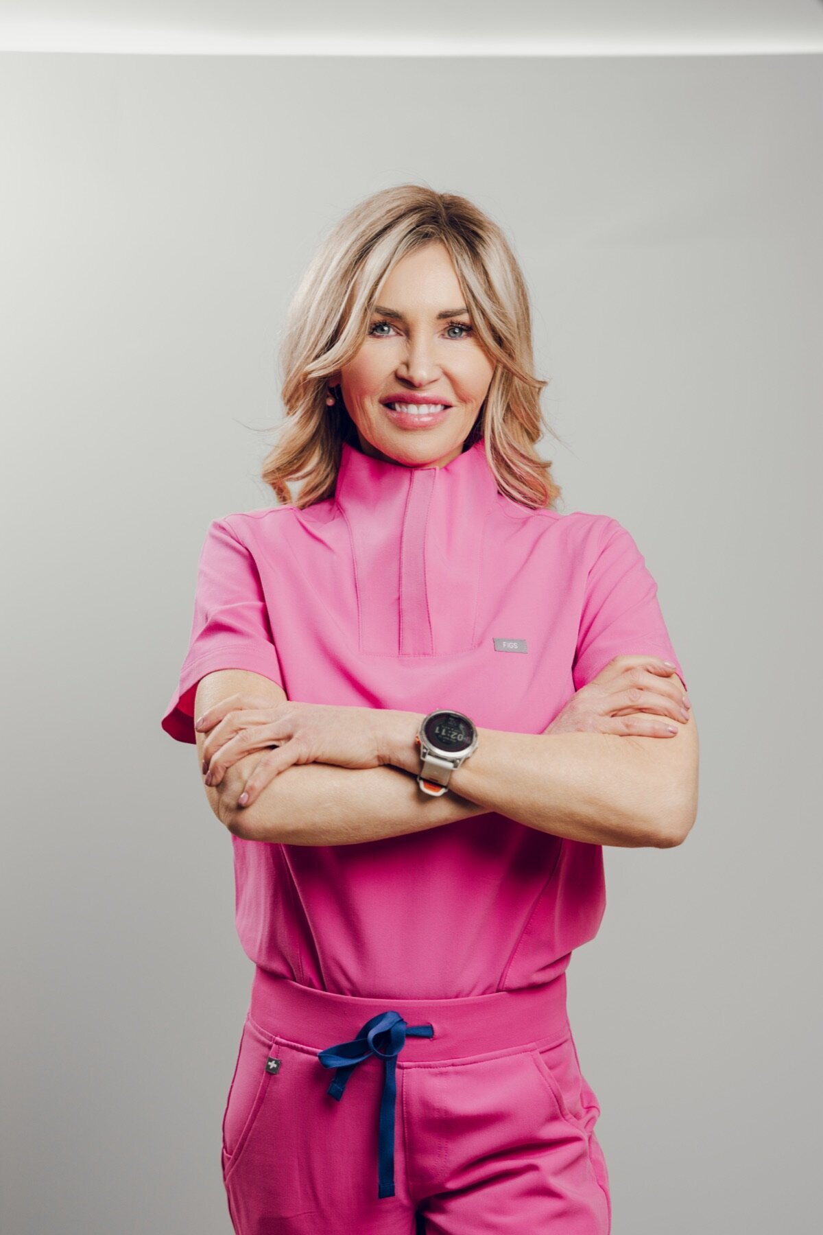 Provider in pink scrubs with arms crossed