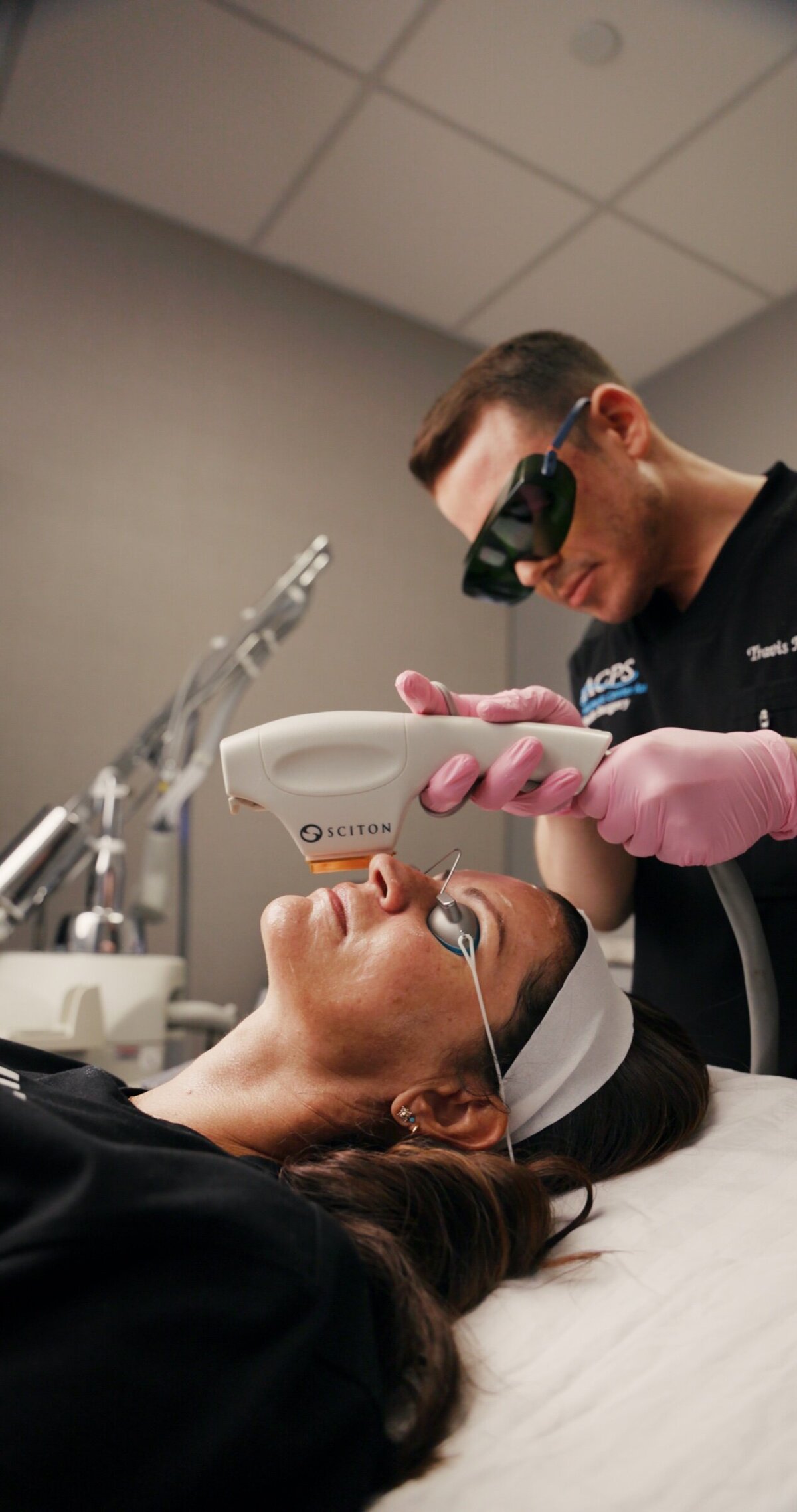 Provider in protective glasses giving a laser treatment