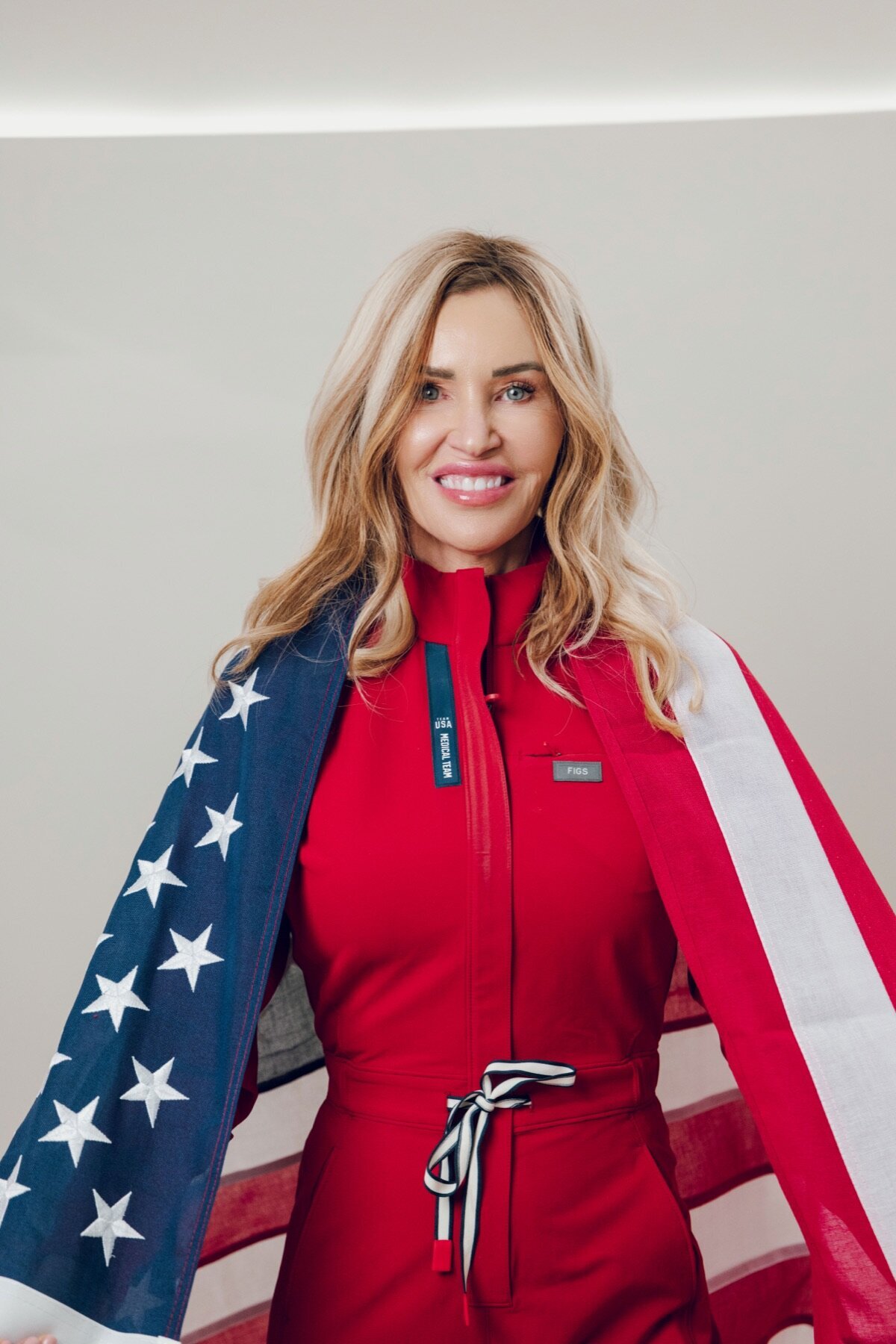Woman in a red outfit wrapped in an American flag for a holiday campaign