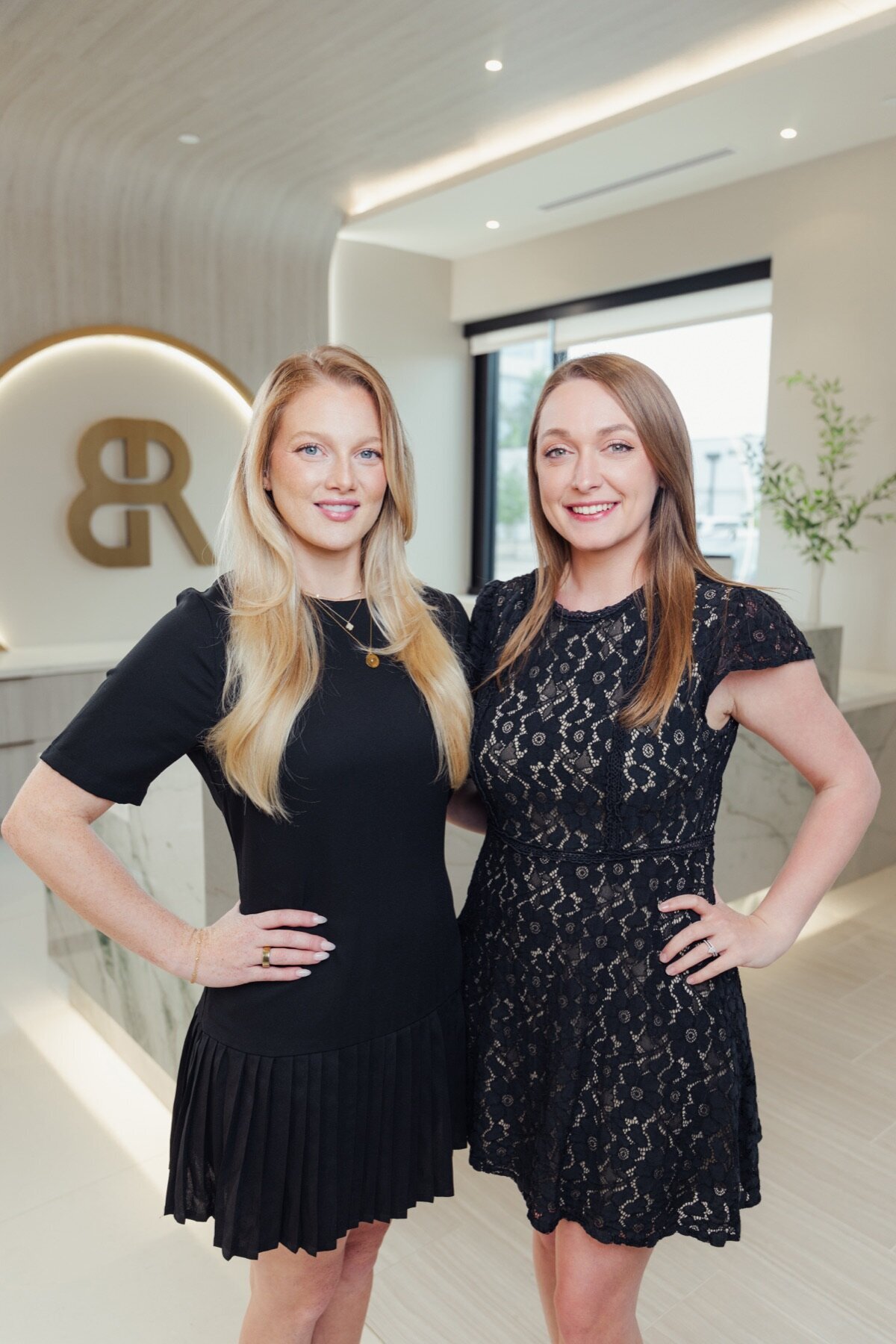 Two Body by Ravi team members in black dresses smiling in the lobby