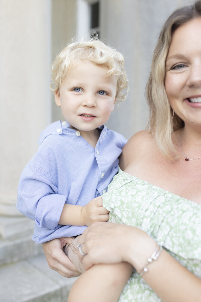 portrait of mom holding blonde toddler boy
