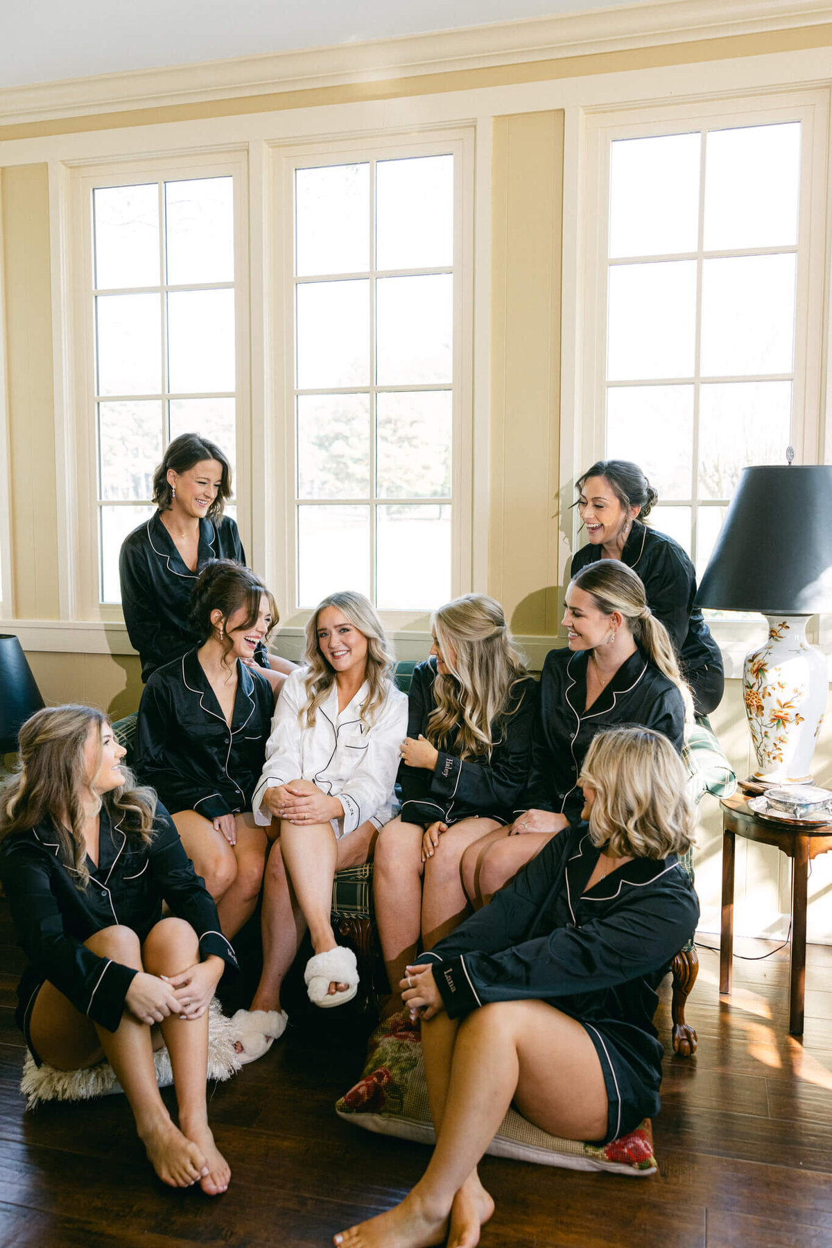 A wedding day photo of the bride with her bridesmaids in the getting ready room