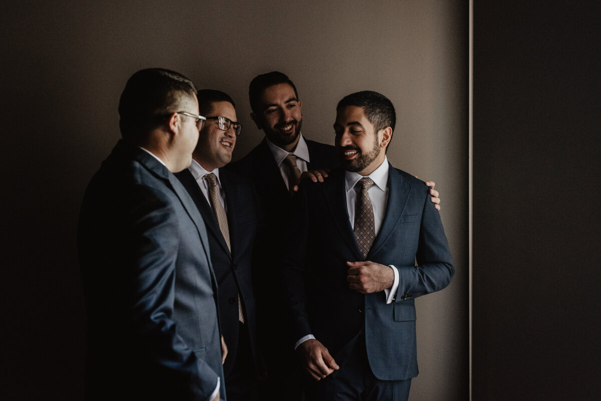 Photographers Jackson Hole capture groom laughing with groomsmen before wedding