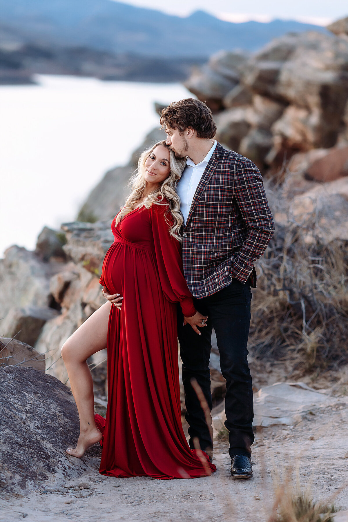 couple posed together holding mamas bump at horseooth for their colorado maternity photos