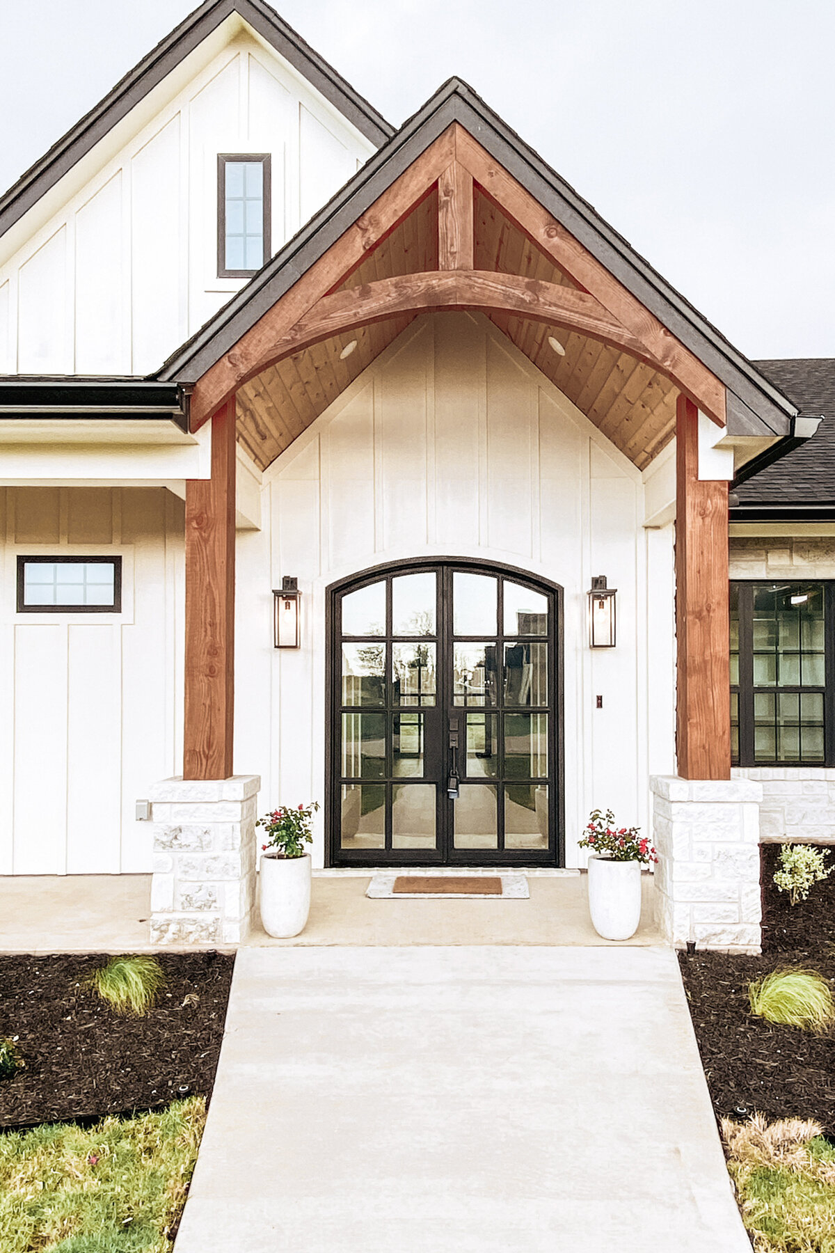double front doors with black divided light and wooden truss overhang