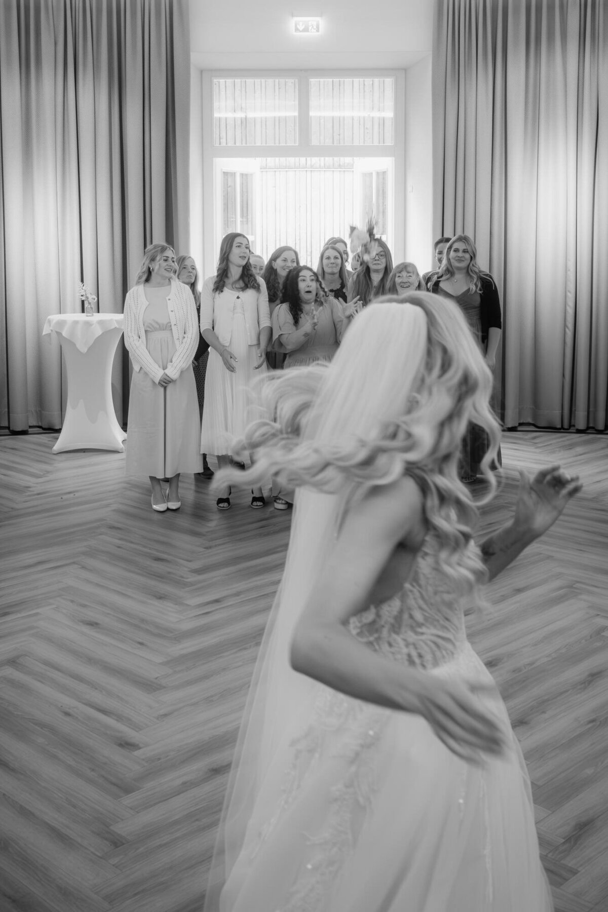 After she threw her wedding bouquet, the bride turns araound to see, who catched it.