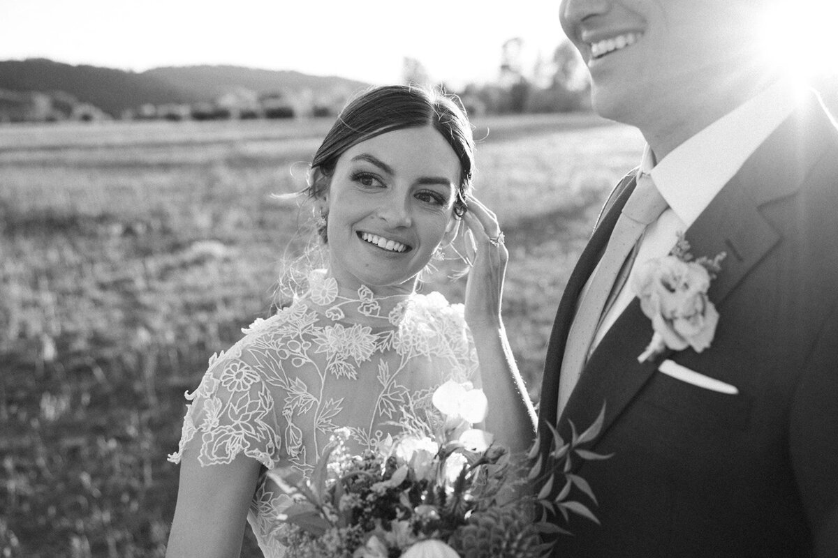 Just married couple walking into the landscapes of Jackson Hole as bride looks back towards the camera in luxury hair and makeup