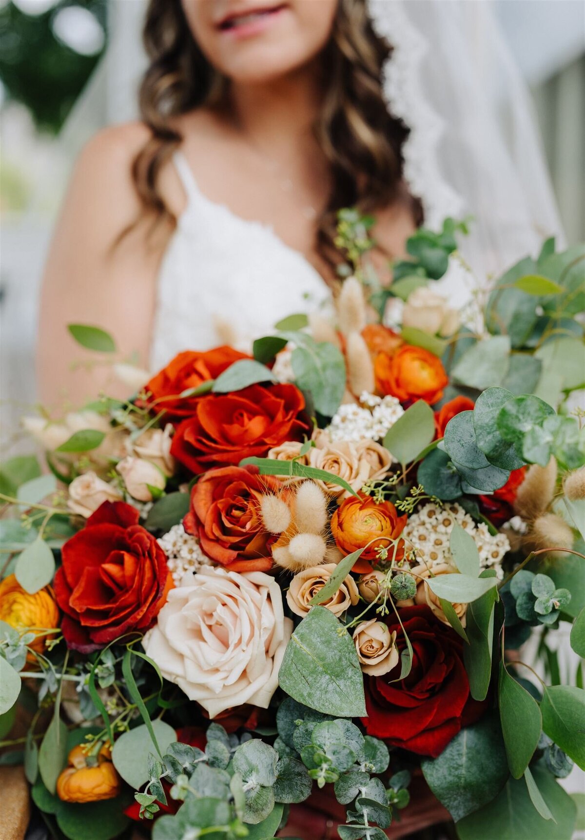 a bride holding a colorful bouquet of flowers