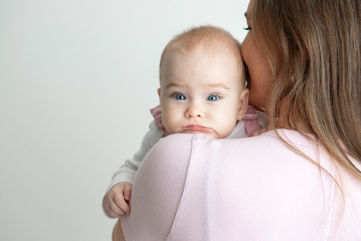 Edmonton mom and baby pose with white studio backdrop