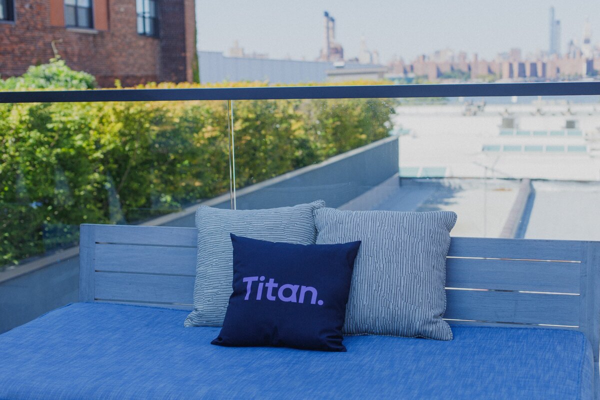 Titan-branded pillow displayed on modern rooftop lounge.
