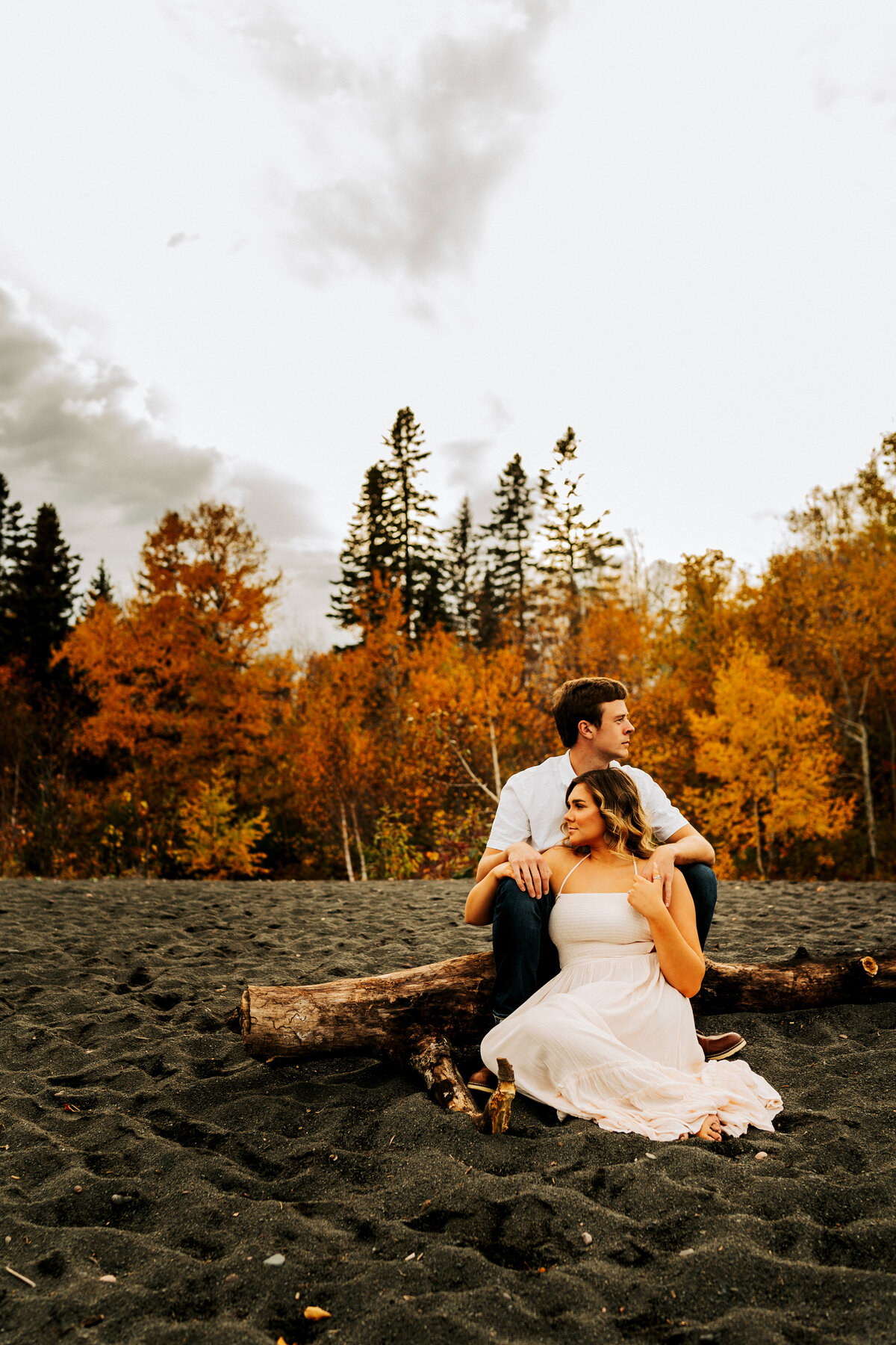 elopement couple sitting on log at beach