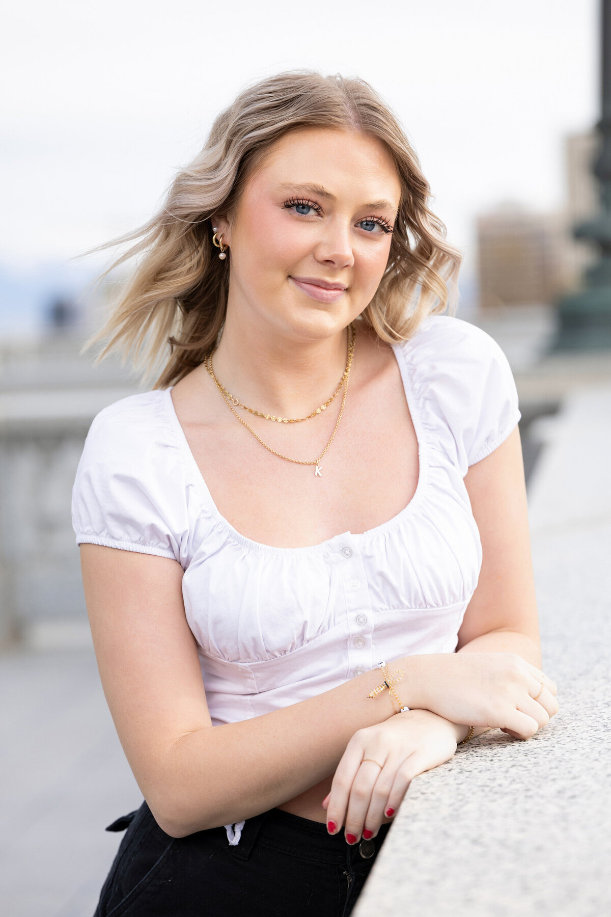 Senior girl in white shirt posing at Utah's capitol in Salt Lake City.