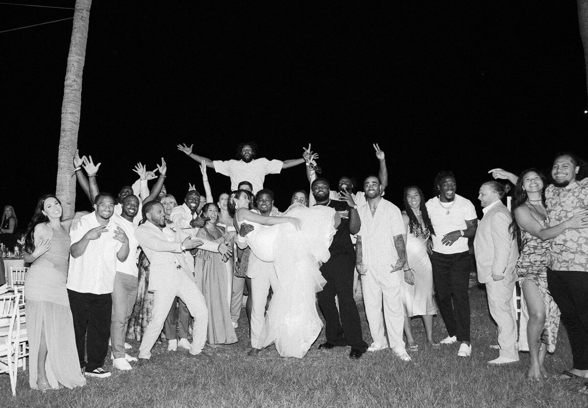 A timeless black and white capture of Andressa and Jonathan’s guests lifting a friend in the air, celebrating an unforgettable wedding night at Table Key, Islamorada. Captured by Claudia Amalia, Islamorada wedding photographer.