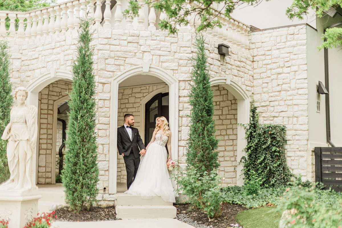 bride and groom outside castle venue standing beside Rolls Royce