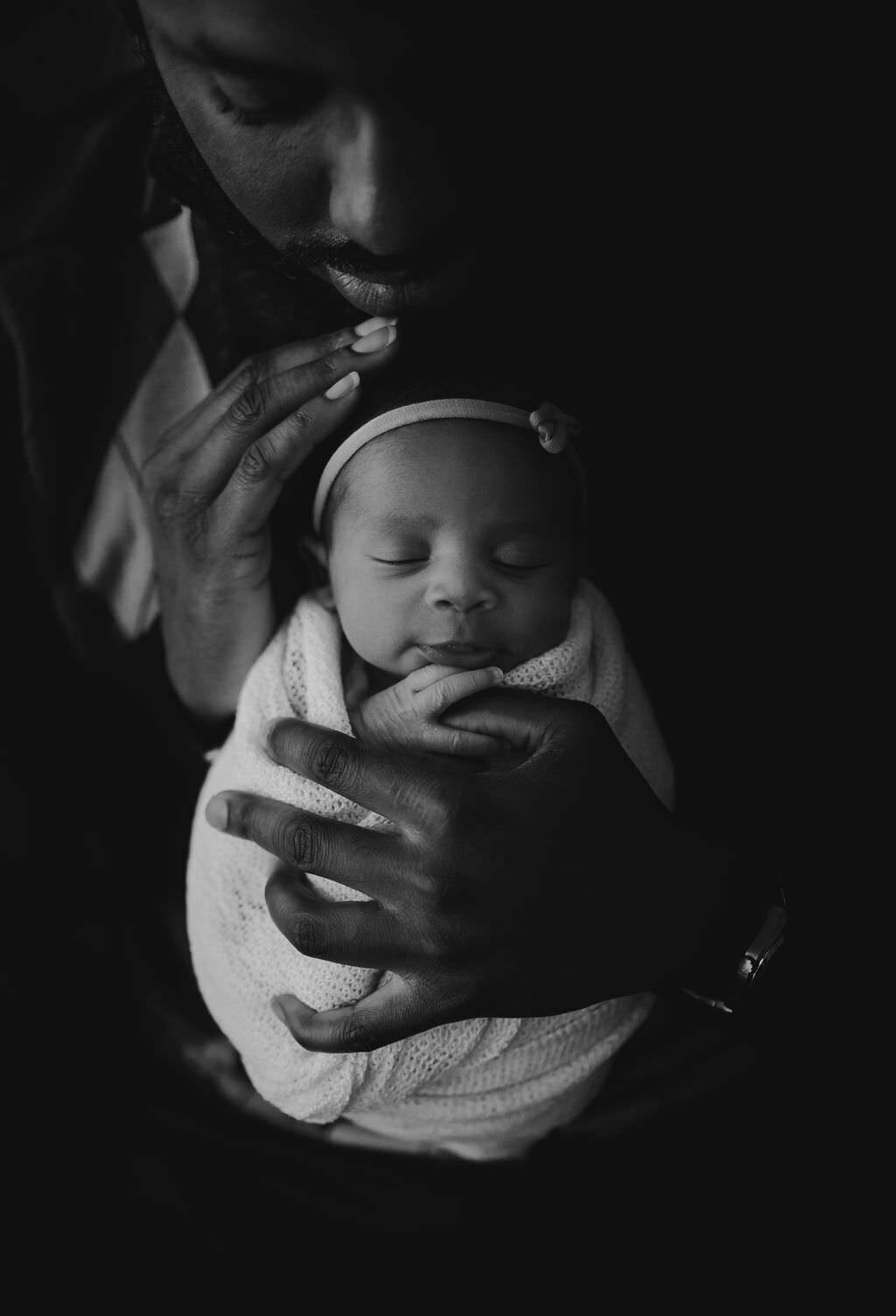 black and white image father holding baby