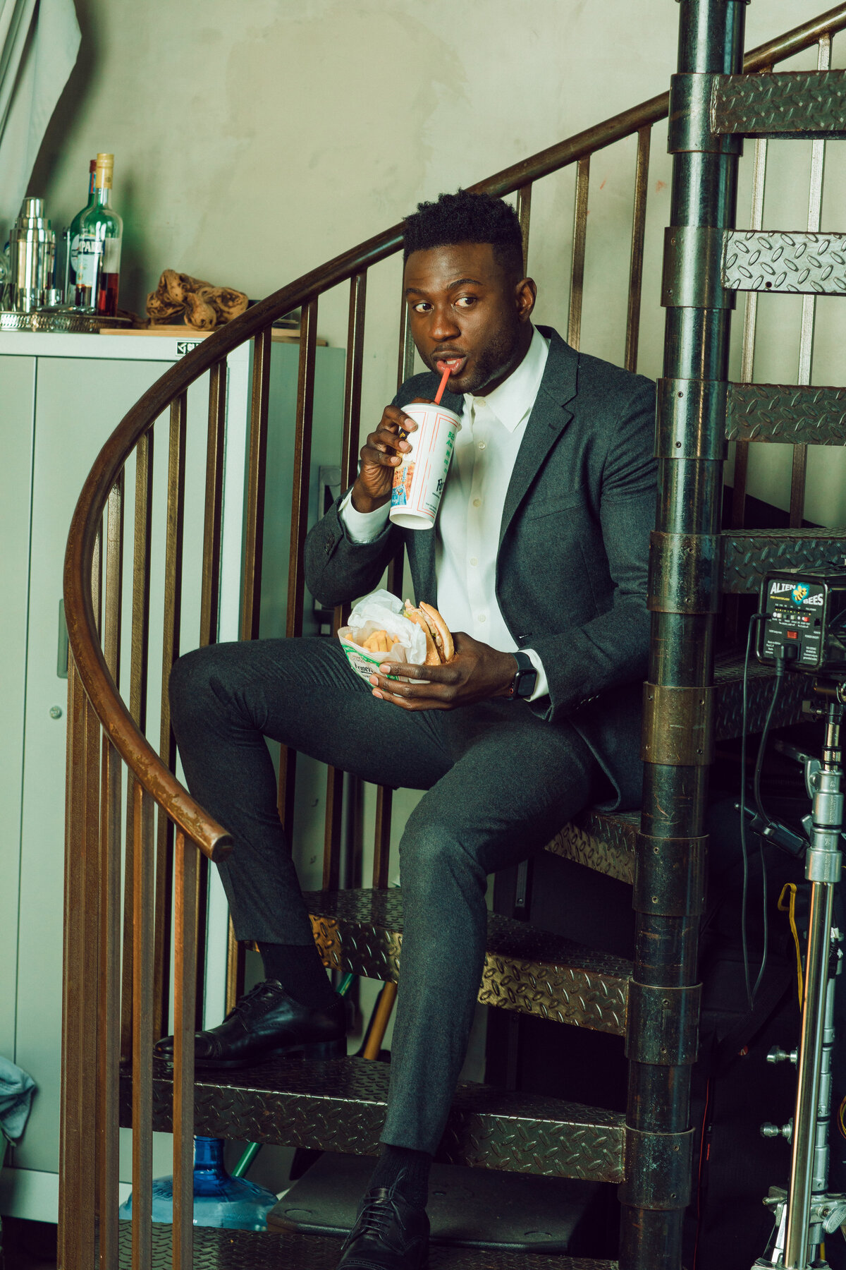 Portrait Photo Of Young Black Man In Suit Sipping a Drink Los Angeles