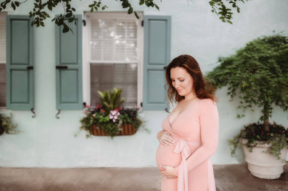 Pregnant woman poses for Maternity Photos at Rainbow Row in Charleston, SC.