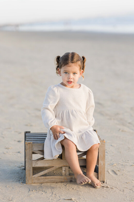 young-girl-sitting-on-crate-Coronado-beach-san-diego