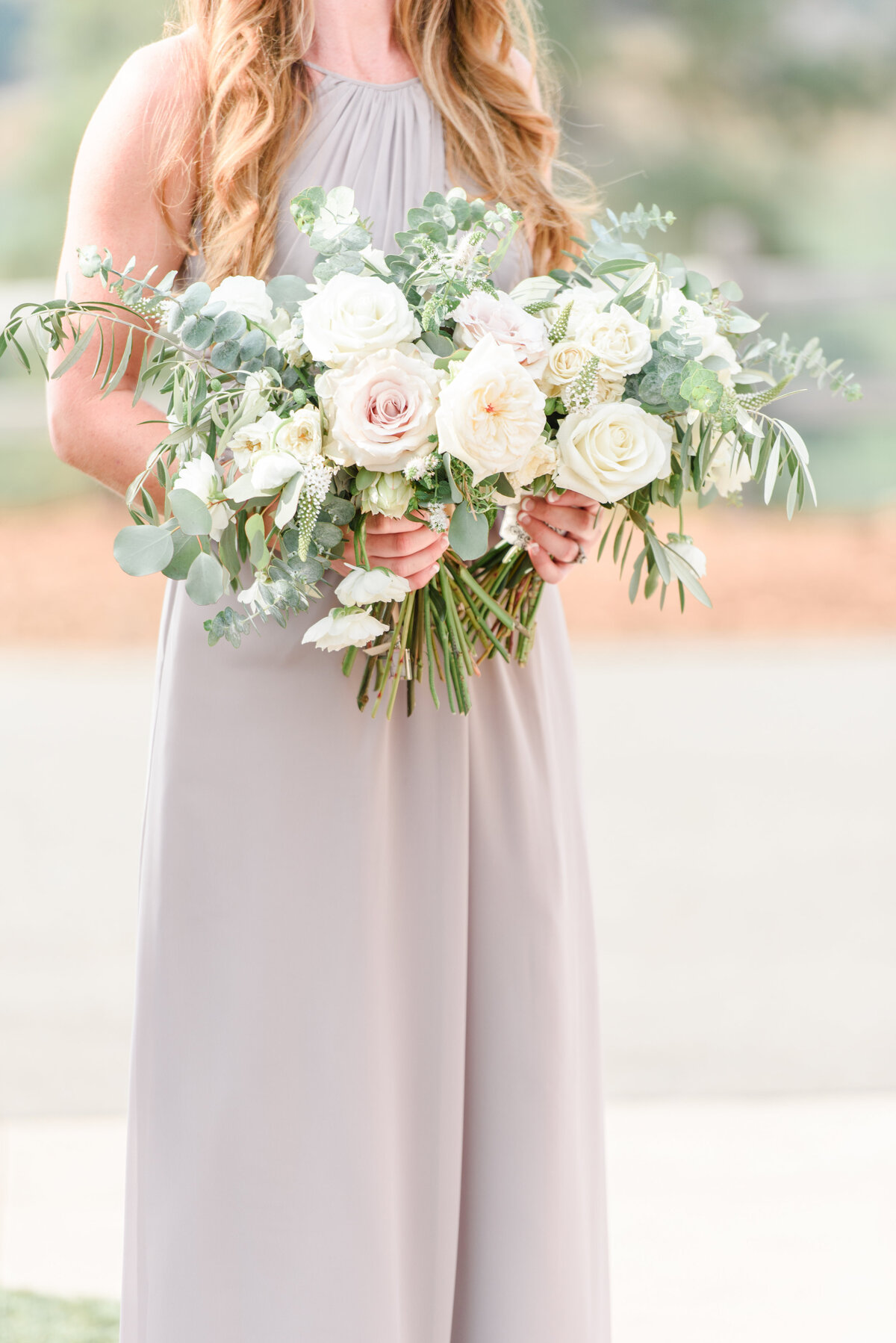 bridesmaid holding a full bouquet of flowers