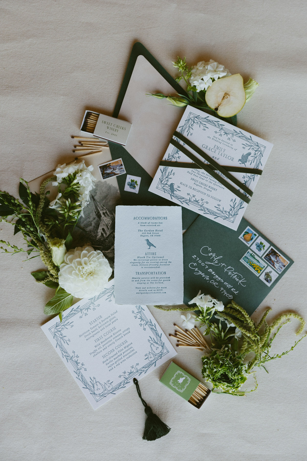 Luxury invitation suite laid out amongst florals, envelopes, stamps and fruit representing full service design and calligraphy by Life in Letters.