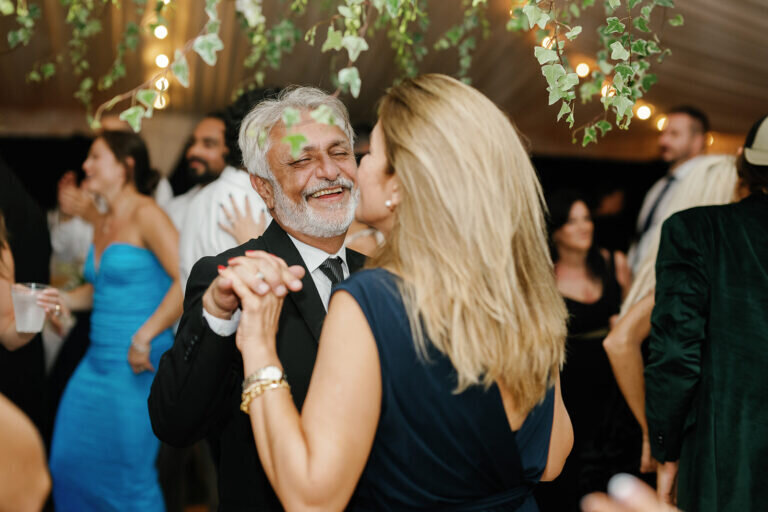 Friends and family gather under twinkling lights, dancing and celebrating the couple’s special night. Destination wedding photography by Claudia Amalia Photography.