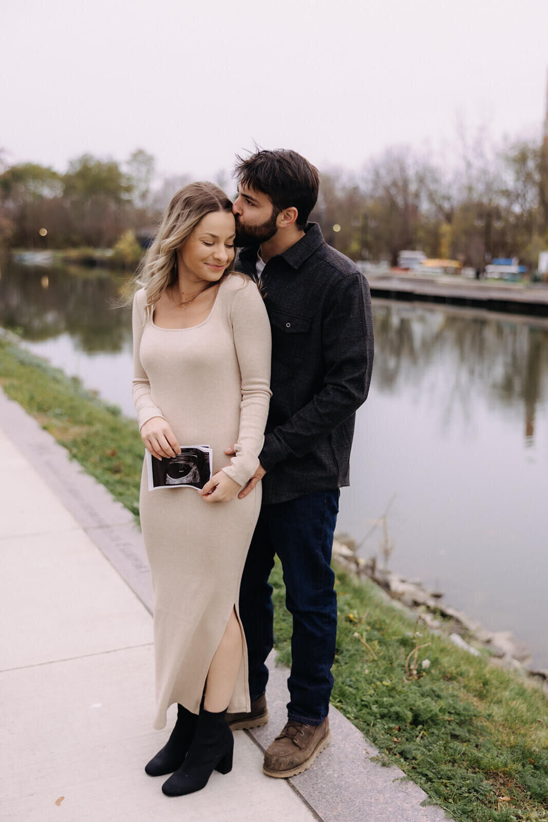 Couple holding scan photo standing by lake for  maternity photos in Finger Lakes New York