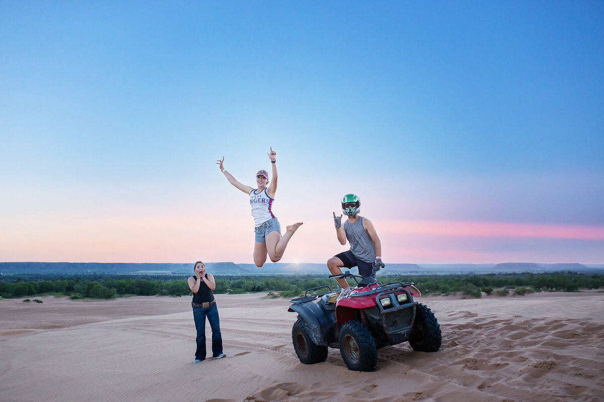 kid standing on 4wheeler while one is jumping in air and one is surprised at Little Sahara State Park OK
