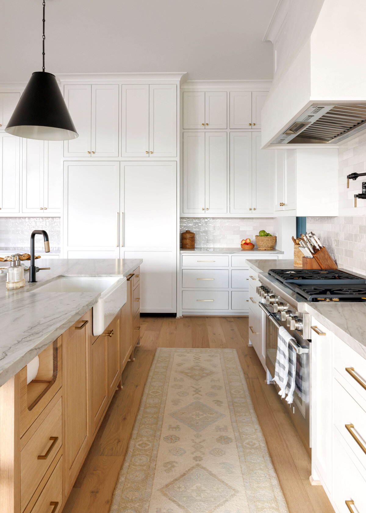 oyster creek studios missouri city new build white kitchen with runner rug and wooden cabinets with black hardware