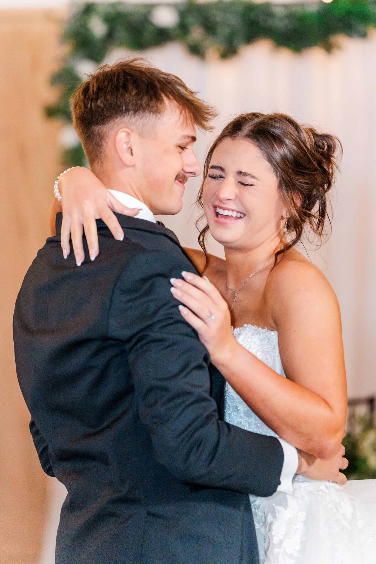 Bride and groom laughing at each other during first dance
